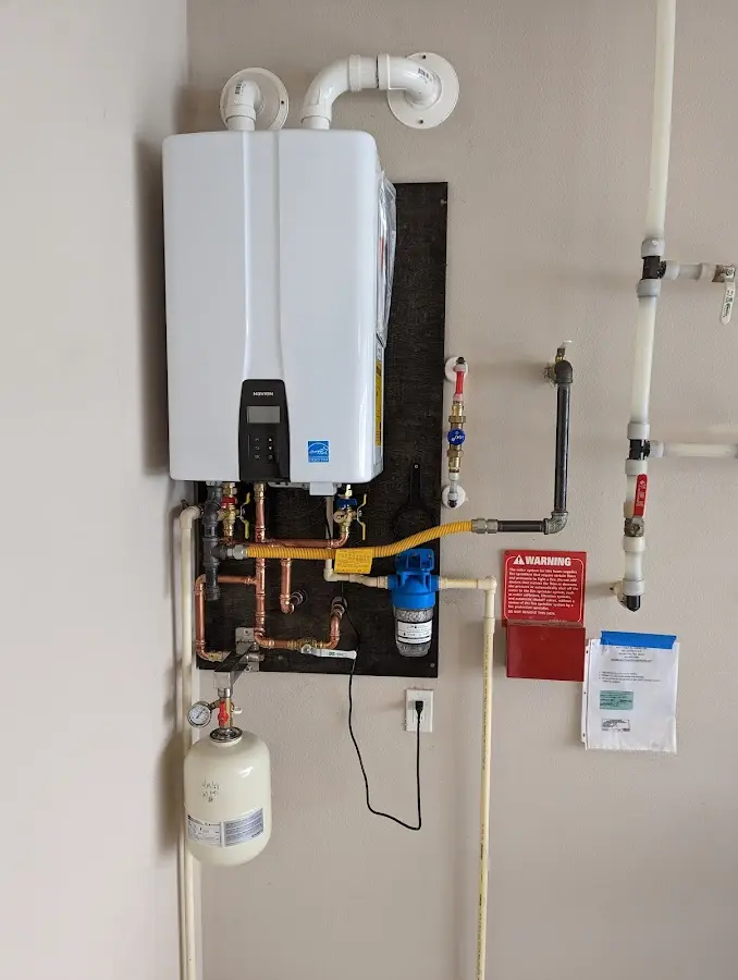 Professional plumber installing copper piping in a Angier home